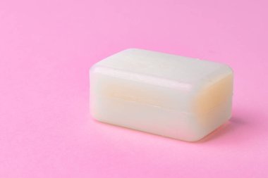 Pembe arka planda izole edilmiş sabun çubuğu. Kapat..