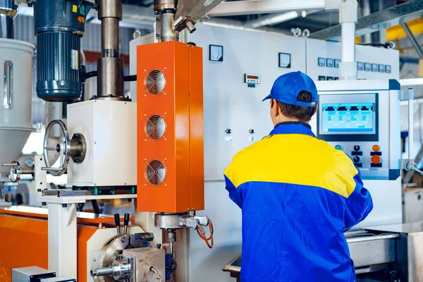 Man worker in manufacturing plant at cable factory machine control computer panel