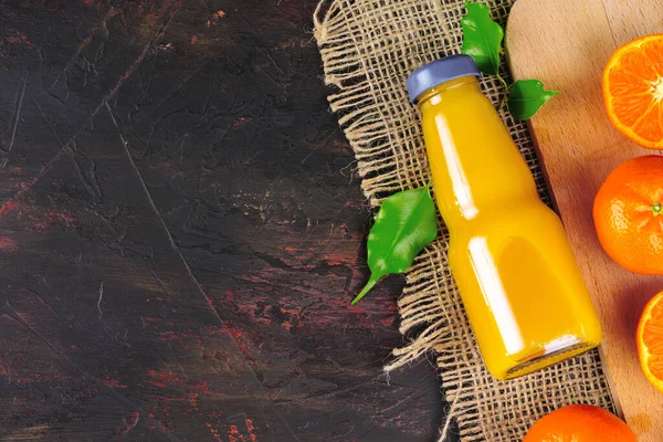 Bottle of orange juice with oranges on wooden table — Stock Photo, Image