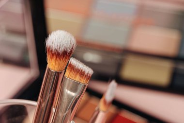 Pembe arka planda dekoratif kozmetik ürünler. Kapat.