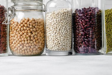 Cam kavanozlarda çiğ tahıl ya da fasulye var. Vejetaryen ve vejetaryen yemekleri.