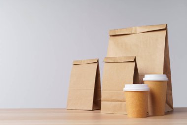 Paketlerde yiyecek ve kahve fincanları var.
