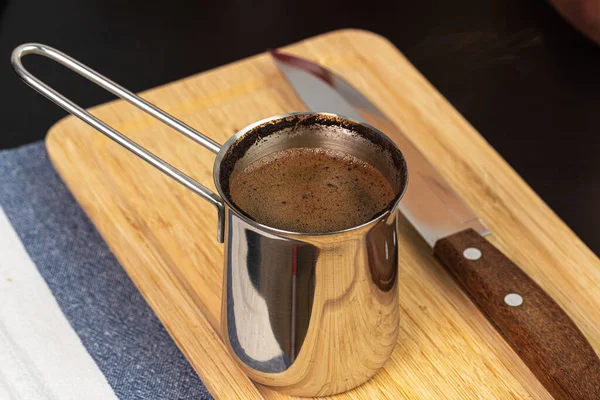 Café preparado en un turco de metal en un mostrador de cocina — Foto de Stock