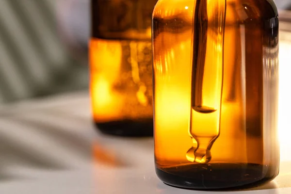 Barna üvegek olajos bőrápoló szérummal közelről — Stock Fotó
