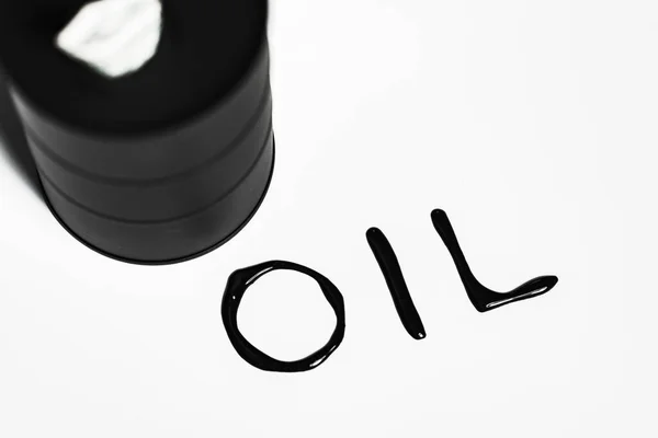 Koncept ropného průmyslu. Rozlitý olej z mini sudu na bílém pozadí — Stock fotografie