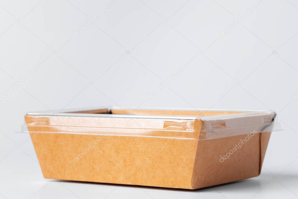 Craft paper disposable box with plastic cover on grey background, copy space