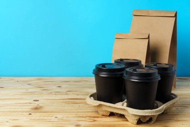 Paketlerde yiyecek ve kahve fincanları var.