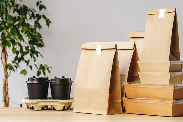 Muchos envases de comida para llevar diversos, caja de pizza, tazas de café y bolsas de papel sobre fondo gris claro —  Fotos de Stock