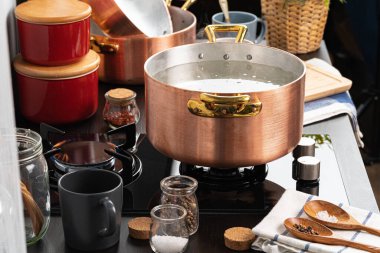 Gaz sobasında kaynar suyla bakır kap.