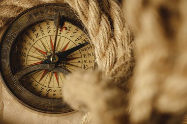 Ahşap zemin üzerinde gemi halatı ve pusula