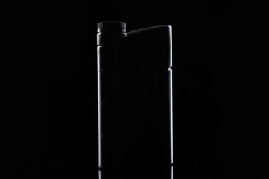 Motor yağı şişesi siyah arka planda, kapat..