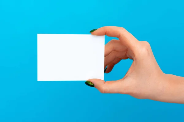 Женщина держит пустую карточку на синем фоне — стоковое фото
