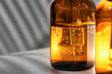 Yağlı cilt serumlu kahverengi cam şişeler. Yaklaş.