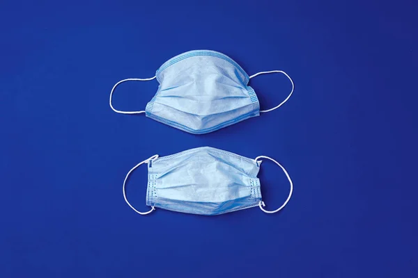 Mavi arka planda tıbbi yüz maskesi. Coronavirus önleme kavramı — Stok fotoğraf