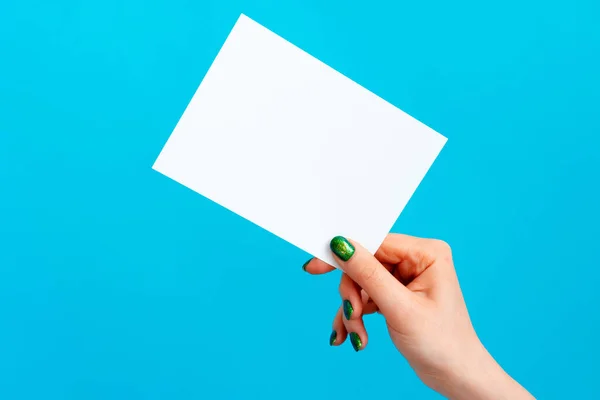 Woman hand holding blank card on blue background — Stock Photo, Image