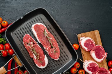 Kızartma tavasında çiğ biftek. Koyu arkaplan.