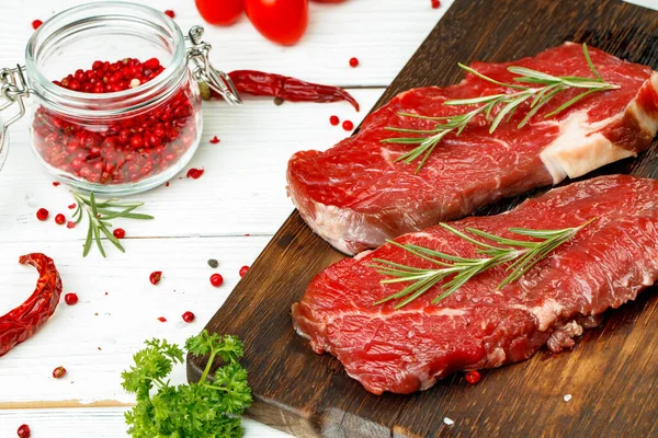 Filetes de ternera con romero sobre tabla de madera — Foto de Stock