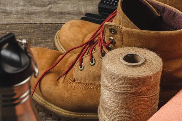 Botas de caminhada e corda hank na placa de madeira — Fotografia de Stock