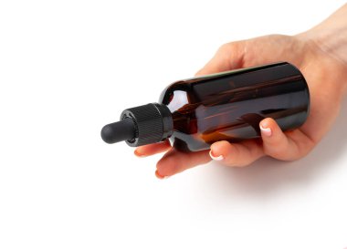 Beyaz üzerinde kozmetik şişesi tutan kadın.