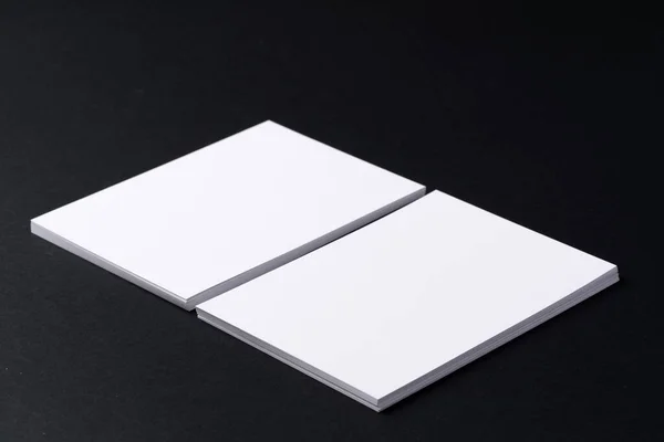 Tarjetas de visita blancas en blanco sobre fondo negro oscuro — Foto de Stock