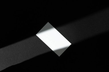 Siyah arka planda fotokopi alanı olan tek bir iş kartı. Gölgeli fotoğraf