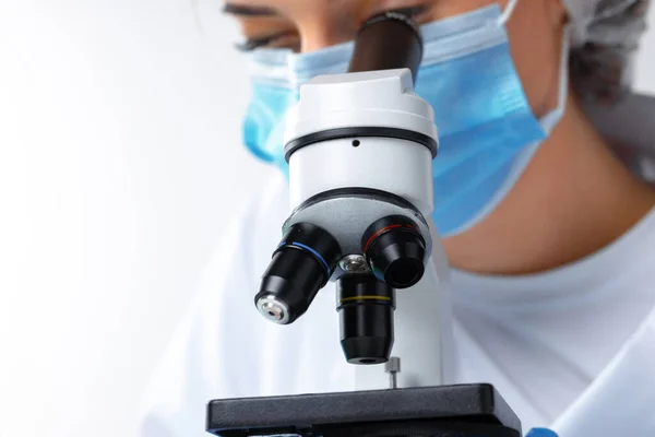 Photo rapprochée d'une femme scientifique travaillant au microscope — Photo