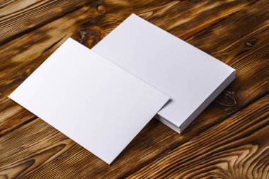 Kahverengi ahşap arka planda beyaz kartvizit yığını