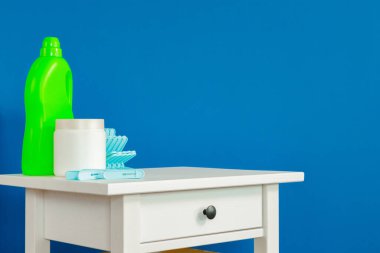 Mavi elbiseler beyaz ahşap masada.