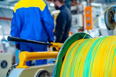 Kablo fabrikasının makine kontrol panelindeki fabrikada çalışan adam.