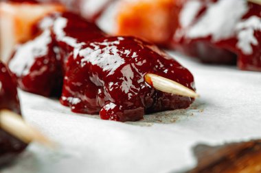 Tahtadaki şişler üzerinde çiğ ciğer kebabı.