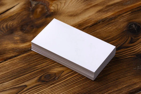 Pilha de cartões de visita brancos no fundo de madeira marrom — Fotografia de Stock