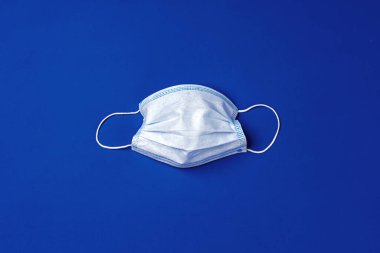 Mavi arka planda tıbbi yüz maskesi. Coronavirus önleme kavramı