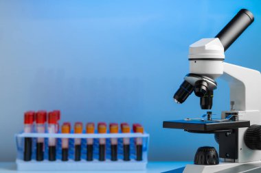 Renkli test tüpleriyle laboratuvar mikroskobu kapat