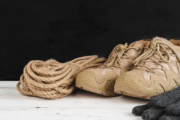 Wandelschoenen en touw hank op houten plank — Stockfoto