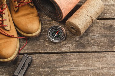 Ahşap zemin üzerinde dağ teçhizatı araçları ile çevrili pusula