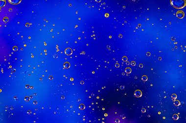 Mavi arka plan ve yağ halkaları. Su kabarcıkları. Kapat..