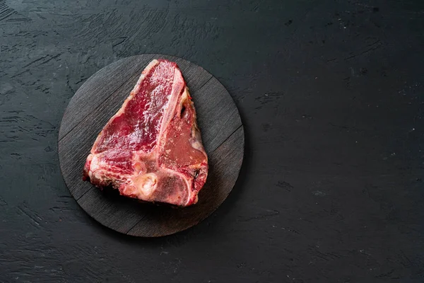 Filete crudo de hueso en T con hierbas sobre tabla de madera — Foto de Stock