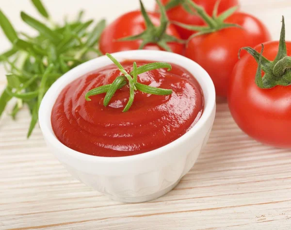 Ketchup or tomato sauce on a wooden background — Stock Photo, Image