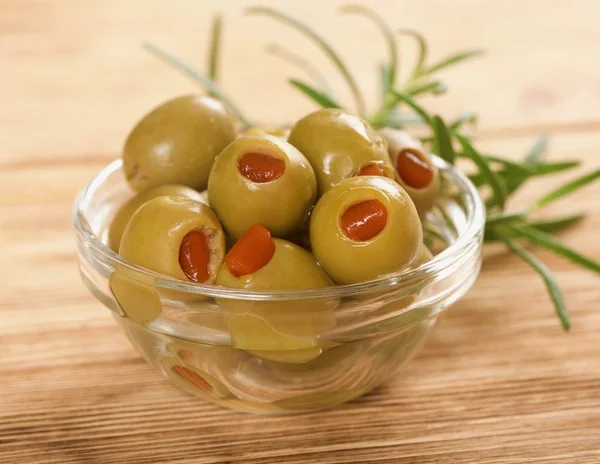 Grüne Oliven auf einem hölzernen Hintergrund — Stockfoto