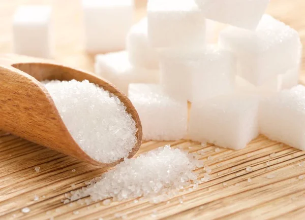 Белый сахар на деревянном фоне — стоковое фото