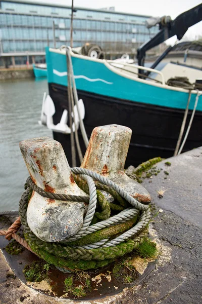 Barco azul y negro acoplado a un amarre de hierro oxidado . —  Fotos de Stock