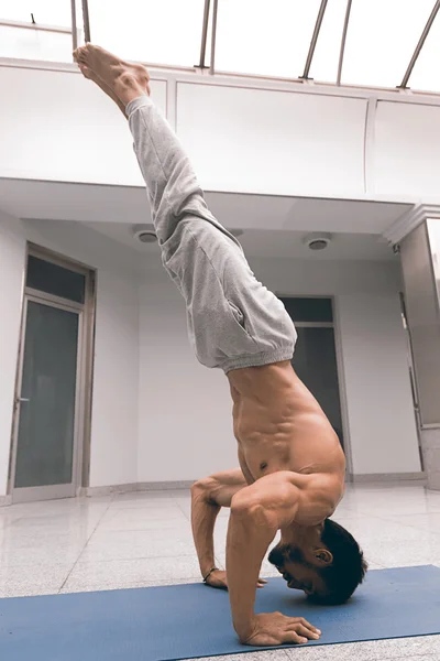 Sportovní silný muž cvičení obtížné jóga pozice. — Stock fotografie