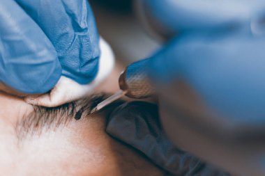 Kalıcı makyaj. Kaşları üzerinde kalıcı makyaj uygulamak güzellik uzmanı.