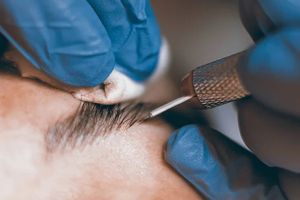 Maquiagem permanente. Cosmetologist aplicando a composição permanente nas sobrancelhas . — Fotografia de Stock