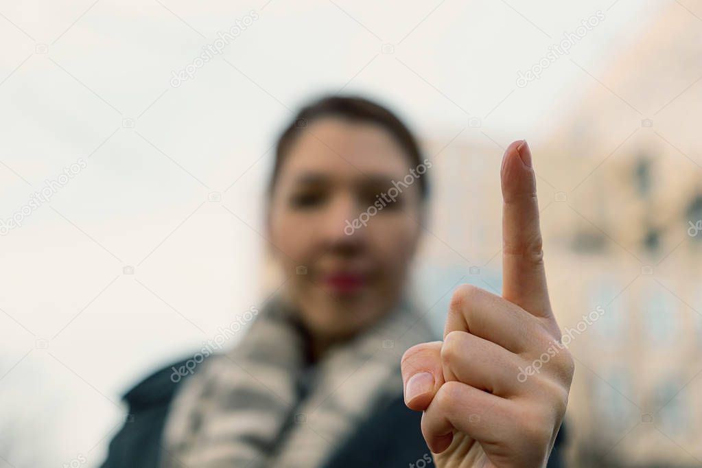 Angry woman warning you. Blurred  woman wagging her finger. Attention, listen to me. Close up finger of young woman.