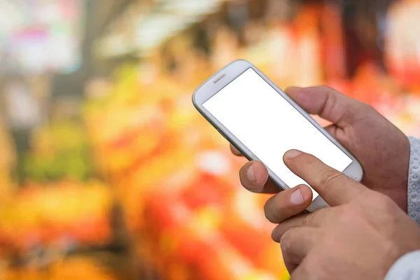 Man controleren boodschappenlijstje op haar smartphone bij supermarkt. — Stockfoto
