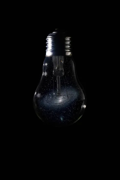 仙女座星系在灯泡上黑暗的背景 — 图库照片