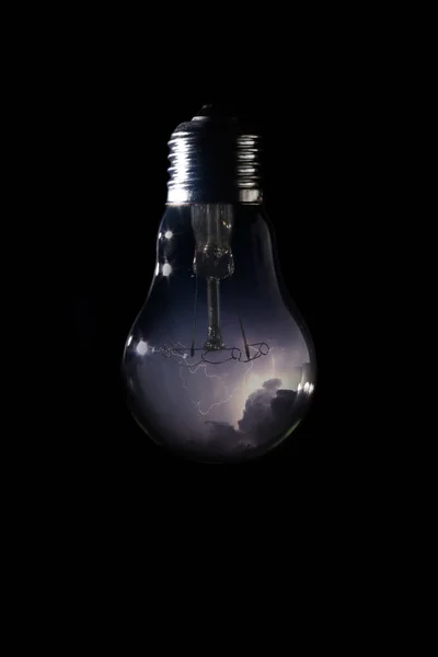 Thunder and storm inside of light bulb on dark background — Stock Photo, Image