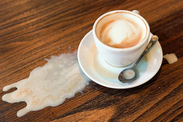 Kapuçino Kupası döktüm. Kahve dökülen leke kaza damla masa üzerinde