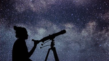 Kadın teleskopuyla yıldızlara izliyor. Saatimizi kadın ve ni